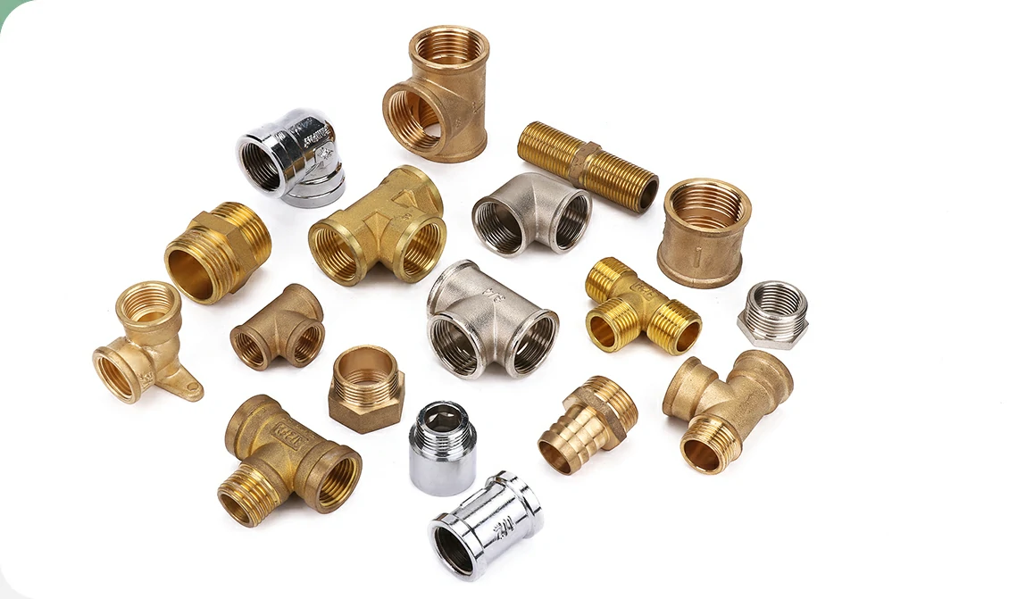 An assortment of brass pipe fittings, adaptors and couplings arranged on a white background