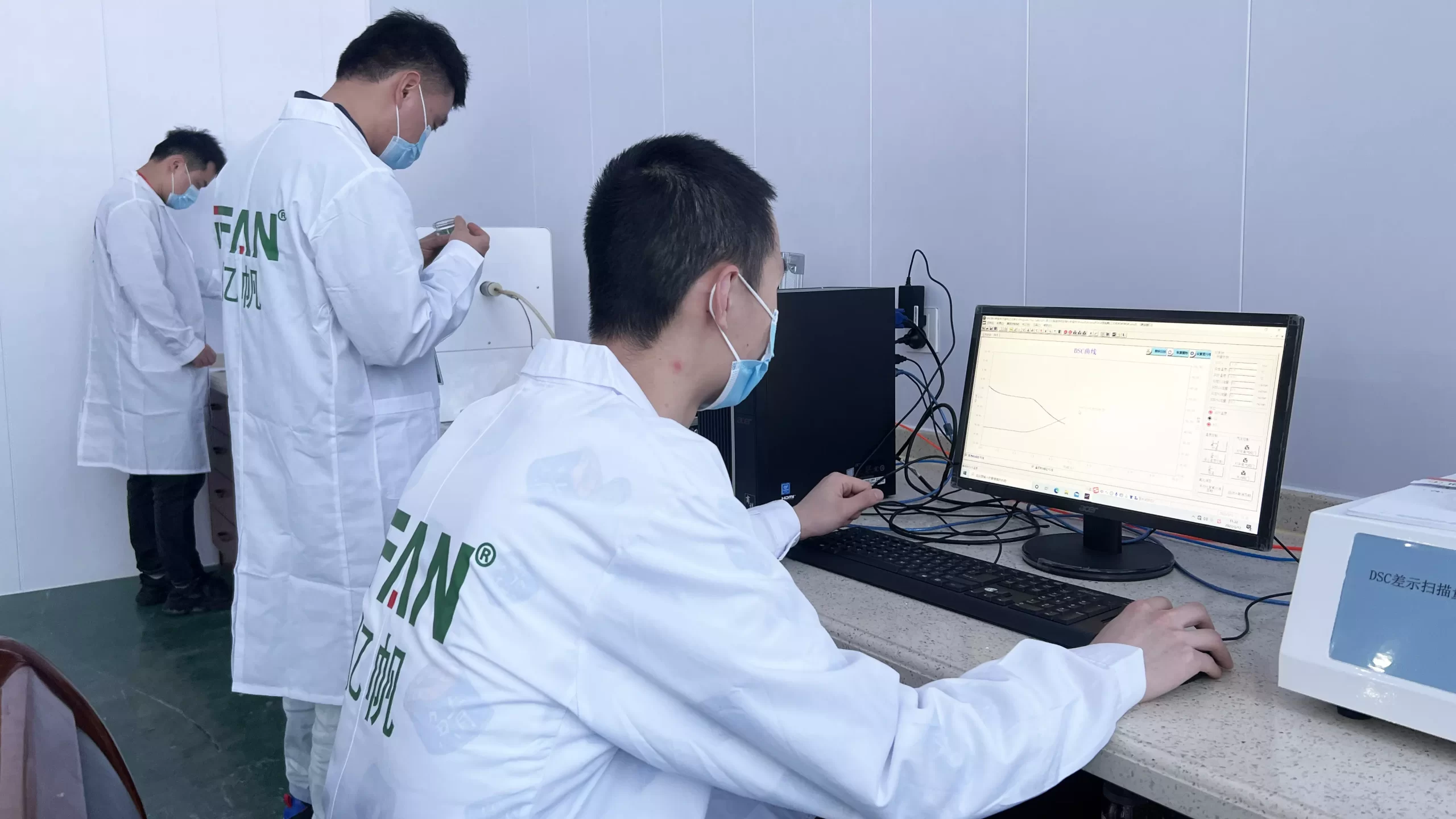 IFANPRO lab technicians running a bench test rig with the instrument output plotted on a connected PC