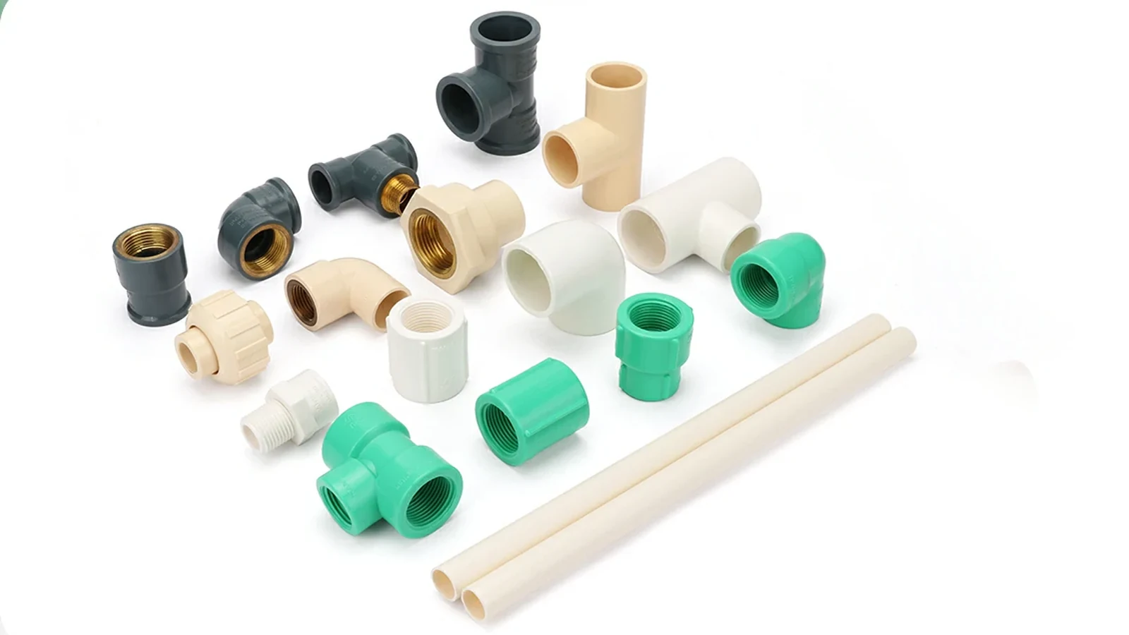 Dark grey PVC-U, cream CPVC and green plastic socket fittings laid out with two lengths of CPVC pipe on a white background
