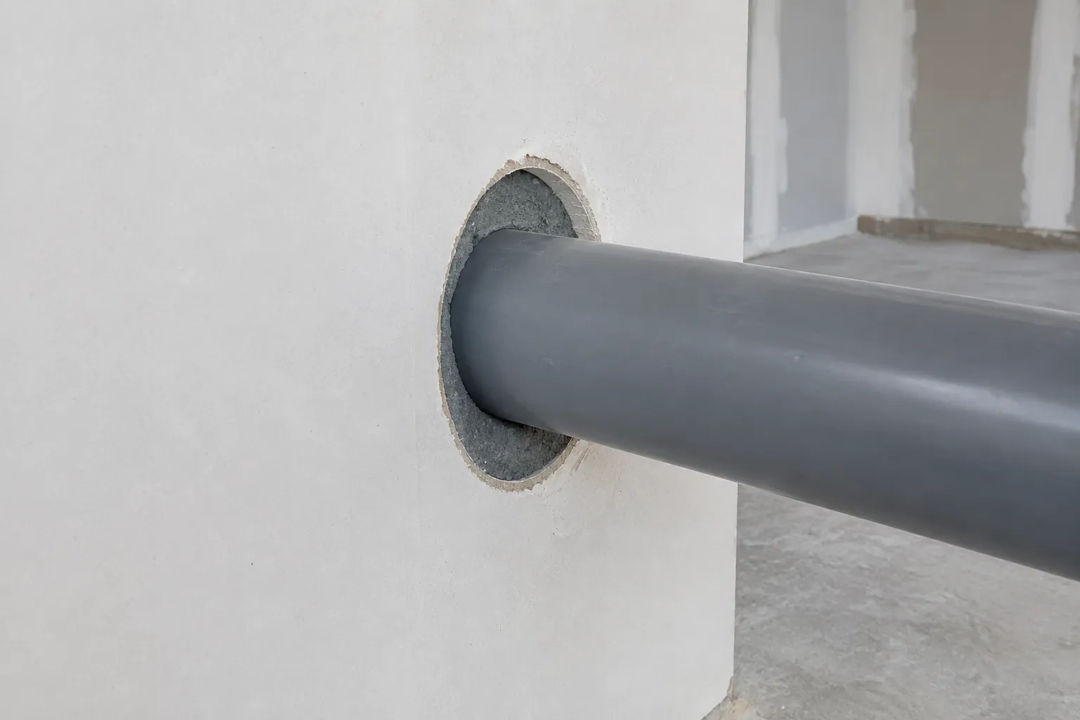 Illustration of a plastic pipe at a wall opening without a claimed firestop rating